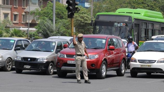A traffic police home guard manages the traffic near Iffco Chowk on MG Road in Gurugram.(Parveen Kumar/ HT Photo)