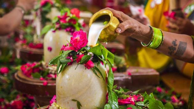 Hindu devotees perform ‘Abhishekam’ to Lord Shiva in the holy month of Shravan at a temple, in Allahabad. (PTI)