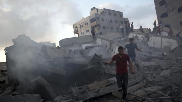 Palestinians inspect the damaged building of Said al-Mis'hal cultural center after it was hit bombed by an Israeli airstrike in Gaza City.(AP File Photo)