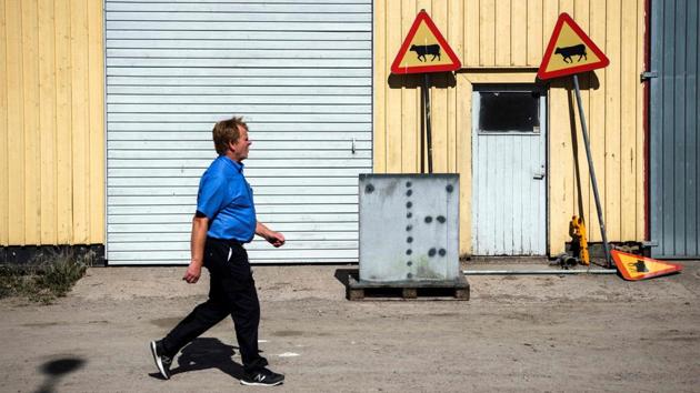 A guard walks past a road sign “Beware of a cow” displayed outside a warehouse at Rodjan, an open prison functioning as a farm in the city of Mariestad. In Sweden, which prioritises rehabilitation over punishment, Alfred is one of 60 inmates preparing to reintegrate into society at this open prison. (Jonathan Nackstrand / AFP) A guard walks past a road sign “Beware of a cow” displayed outside a warehouse at Rodjan, an open prison functioning as a farm in the city of Mariestad. In Sweden, which prioritises rehabilitation over punishment, Alfred is one of 60 inmates preparing to reintegrate into society at this open prison. (Jonathan Nackstrand / AFP)