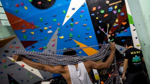 Myanmar climber Aung Khaing Myint (C) coils a rope as Zaw Zin Khine (R) prepares gear for rock climbing training at a gym in Yangon. The three climbers, now waiting for the right window in the weather to start their expedition, have been in intensive training for months, including a trip to Nepal and sessions in a Yangon gym, wearing masks to simulate low-oxygen levels at altitude. (Ye Aung Thu / AFP) Myanmar climber Aung Khaing Myint (C) coils a rope as Zaw Zin Khine (R) prepares gear for rock climbing training at a gym in Yangon. The three climbers, now waiting for the right window in the weather to start their expedition, have been in intensive training for months, including a trip to Nepal and sessions in a Yangon gym, wearing masks to simulate low-oxygen levels at altitude. (Ye Aung Thu / AFP)