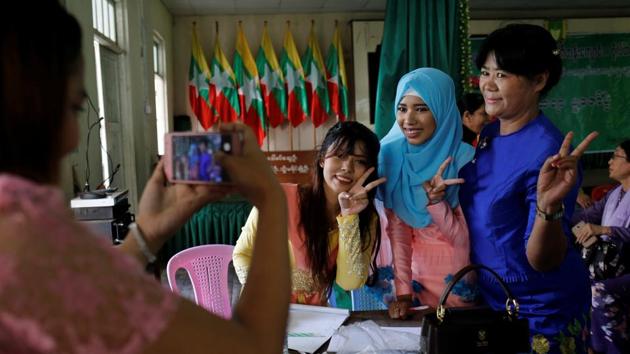 Win Lae Phyu Sin poses her former classmates and school teacher at her reunion. A year on, she brings to every lesson two bags packed with eyeliners, brushes and small mirrors for every student. At one recent session, she discussed skin types before handing out bottles of foundation and eyeshadow for students to try. (Ann Wang / REUTERS) 