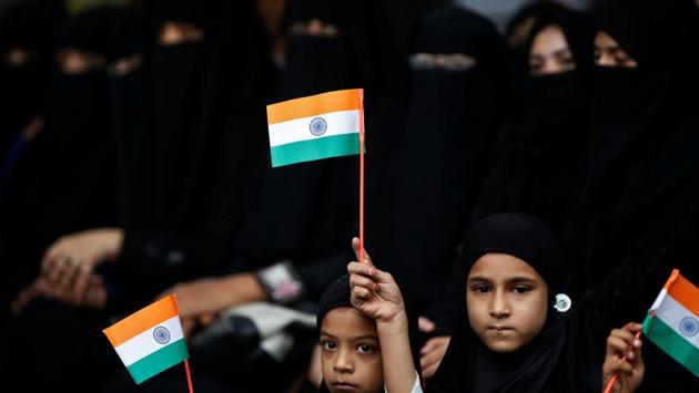 Girls hold national flags as they attend a flag hoisting ceremony during Independence Day celebrations in Ahmedabad. (Amit Dave / REUTERS)