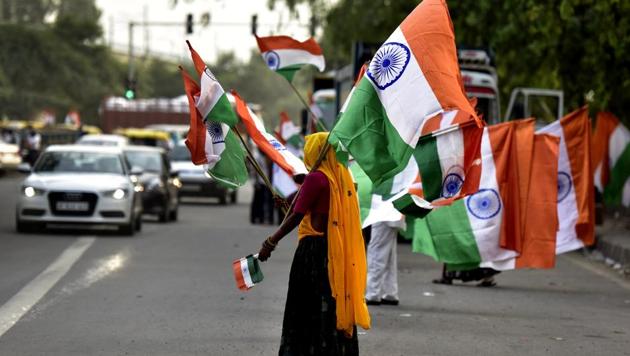 A woman sells the national flag on the eve of Independence Day .(Virendra Singh Gosain/HT Photo)