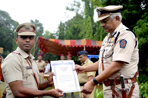 PSI Sunil Shivaji Gurav being awarded by Navi Mumbai police commissioner Sanjay KUmar on Wednesday.(Bachchan Kumar/HT)