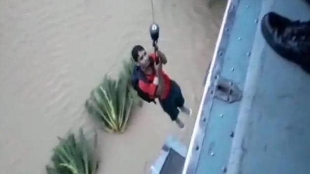 A man being airlifted by Indian Air Force personnel from a flooded district in Kerala.(ANI video grab)