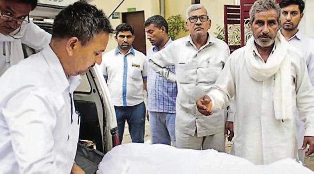 Relatives of Ishwar Singh, a government official (patwari), who was shot dead on Tuesday, with his body.(HT Photo)