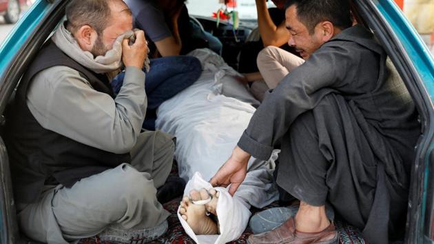 Afghan men mourn over a dead body after a blast outside a hospital in Kabul, Afghanistan August 15, 2018. (REUTERS) Afghan men mourn over a dead body after a blast outside a hospital in Kabul, Afghanistan August 15, 2018. (REUTERS)