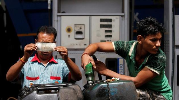 A worker checks a 500 rupee note as a man fills diesel in containers at a fuel station in Kolkata.(REUTERS File Photo)