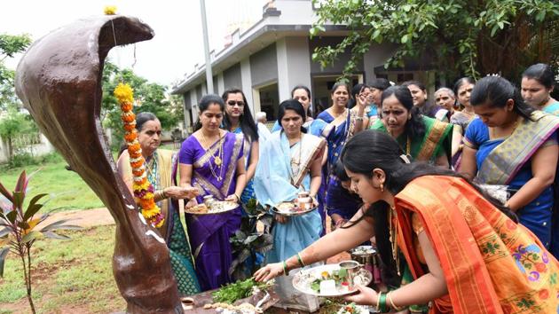 On the occasion of Naagpanchami, women offer prayers to snakes for the well-being of their families. On the occasion, devotees offer milk to the snakes to ensure “that they take care of their family”. A scene from Shahunager, Chinchwad, on Wednesday.  (HT PHOTO) 