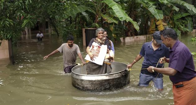 An elderly woman is rescued in a cooking utensil after her home was flooded in Thrissur, Kerala on Thursday.(AP photo)
