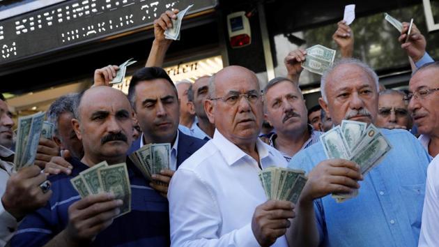 Businessmen holding US dollars stand in front of a currency exchange office in response to the call of Turkish President Tayyip Erdogan on Turks to sell their dollar and euro savings to support the lira, in Ankara, Turkey. (Umit Bektas / REUTERS) Businessmen holding US dollars stand in front of a currency exchange office in response to the call of Turkish President Tayyip Erdogan on Turks to sell their dollar and euro savings to support the lira, in Ankara, Turkey. (Umit Bektas / REUTERS)