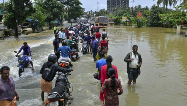 People move past a flooded road in Thrissur, Kerala, Friday, Aug. 17, 2018.(AP)