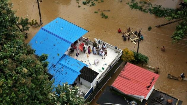 People wait for aid on the roof of their house at a flooded area in Kerala, August 17, 2018. REUTERS/Sivaram V(Reuters)