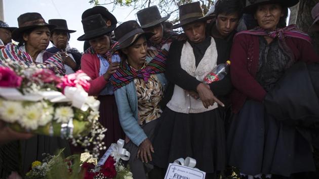Relatives look at the remains of their loved ones before their burial at the cemetery in Quinuas, in Peru's Ayacucho province. The skeletal remains of 14 people were recently turned over to loved ones under an innovative new law that authorities hope will speed up what has long been a lengthy and burdensome process to identify those killed in the conflict. (Rodrigo Abd / AP)