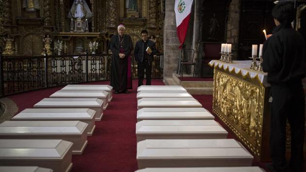 Ayacucho's Bishop Salvador Jose Miguel Pineiro, left, stands with an assistant behind the coffins of villagers. More than 20,300 Peruvians are still considered “disappeared” in the struggle between Peru’s military and Shining Path rebels during the 1980s and 1990s. Public prosecutors with heavy caseloads and few resources have been unable to identify suspects or help families find their missing relative’s remains in the vast majority of cases. (Rodrigo Abd / AP)