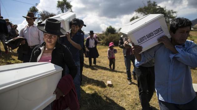 Relatives of people who were killed carry their remains to the cemetery for a proper burial. The new mandate is also aimed at helping families whose relatives were informally buried. (Rodrigo Abd / AP)
