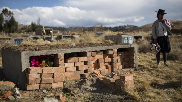 Flowers stand inside the niche of Fortunate Ventura Huamacusi, on the day of his proper burial at the cemetery in Rosaspata. The family of Alberto Ramos is among the first to benefit from that aspect. Military officers accused him of belonging to the Shining Path and shot him to death. Hours later, his frightened relatives buried him in a rural cemetery and never got a death certificate to formally declare his violent end. (Rodrigo Abd / AP)