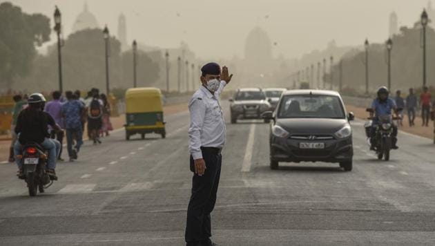 A traffic cop manages traffic as he wears a pollution mask during hazy weather at Rajpath, in New Delhi.(HT File Photo)