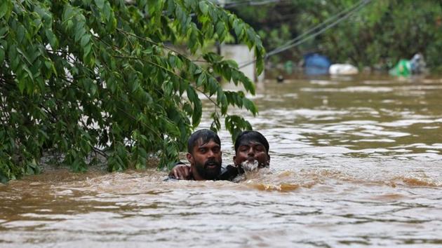 A man rescues a drowning man from a flooded area after the opening of Idamalayr, Cheruthoni and Mullaperiyar dam shutters following heavy rains, on the outskirts of Kochi. (REUTERS) A man rescues a drowning man from a flooded area after the opening of Idamalayr, Cheruthoni and Mullaperiyar dam shutters following heavy rains, on the outskirts of Kochi. (REUTERS)
