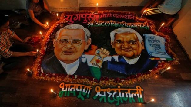Students place candles around a painting featuring former Prime Minister Atal Bihari Vajpayee to pay him homage in Maharashtra. (Reuters Photo)