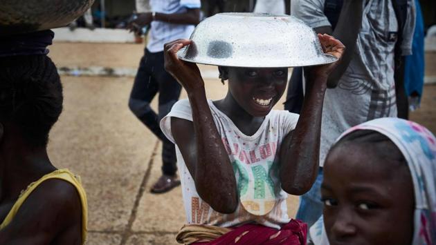 A girl poses with a metal bowl over her head on the sidelines of a protest against the incumbent Malian president in Bamako, on the eve of the second round of presidential elections in Mali. (Michele Cattani / AFP) A girl poses with a metal bowl over her head on the sidelines of a protest against the incumbent Malian president in Bamako, on the eve of the second round of presidential elections in Mali. (Michele Cattani / AFP)