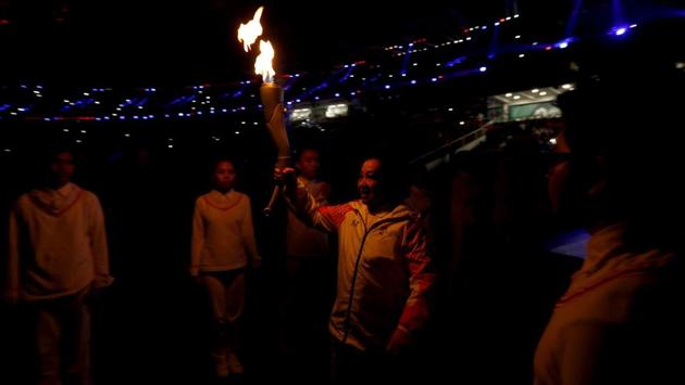 A participant carries the flame during the Opening Ceremony. (REUTERS) A participant carries the flame during the Opening Ceremony. (REUTERS)