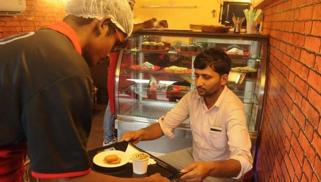 A customer receives his coffee from one of the HIV+ youths who run the cafe in south Kolkata. (Samir Jana/ HT Photo) A customer receives his coffee from one of the HIV+ youths who run the cafe in south Kolkata. (Samir Jana/ HT Photo)
