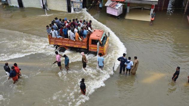 People crossing Pandalam in Pathanamthitta district of Kerala. At least 23 more deaths were reported across rain-devastated Kerala on Saturday. (Raj K Raj/HT Photo)