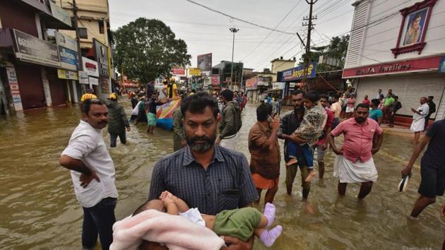 A volunteer rescuing a child at Pandalam in Pathanamthitta district of Kerala. (Raj K raj/HT Photo)