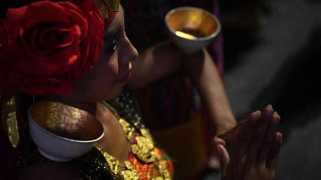 A traditional dancer balances bowls on her body. (AFP) A traditional dancer balances bowls on her body. (AFP)