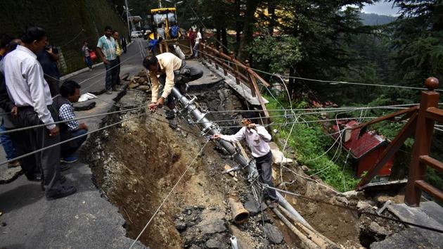 Electricity department workers during the repair work of fallen electricity pole due to landslide near Himachal Pradesh Vidhan Sabha, in Shimla. (Deepak Sansta / HT Photo) 