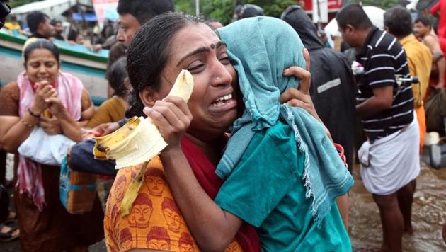 A woman cries as she holds her son after they were evacuated from a flooded area in Aluva in Kerala, on August 18, 2018.(Reuters)