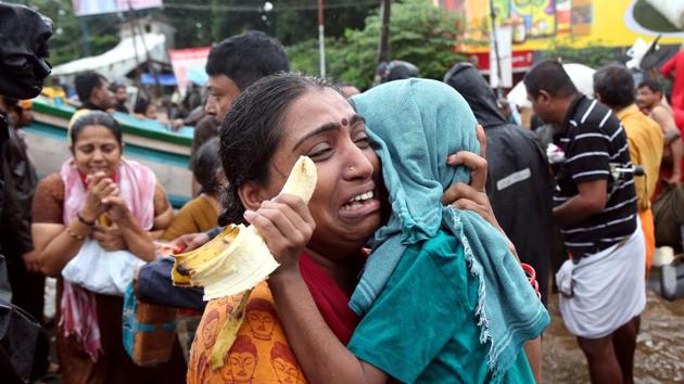 A woman cries as she holds her son after they were evacuated from a flooded area in Aluva, Kerala. (Sivaram/V REUTERS)