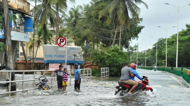 Pedestrians and motorists wade through flooded streets in Kozhikode, about 385 km north of Trivandrum in Kerala, on August 17, 2018.(AFP)