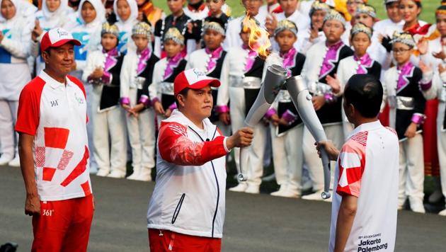 Indonesian President Joko Widodo (R) hands over the Asian Games torch to head of the Indonesian Asian Games 2018 Organizing Committee Erick Thohir (C) as Indonesian badminton hero Rudy Hartono (L) stands, at the presidential palace in Jakarta, Indonesia(REUTERS)