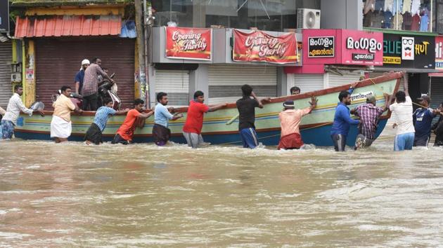 Fishermen, volunteers and rescue personnel evacuate residents on a boat due at Panadala, in Pathanamthitta district of Kerala.(Raj K Raj/HT Photo)