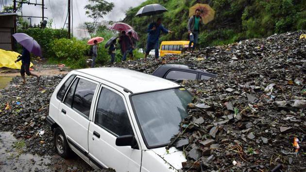A car is buried under the debris after heavy rainfall triggered a landslide on ISBT-Dhalli bypass, Shimla, Himachal Pradesh. (Deepak Sansta / HT Photo) 