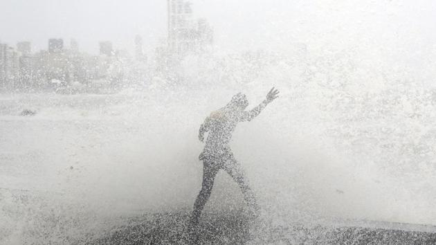 A man loses his balance as he gets drenched by a large wave during high tide at a seafront in Mumbai, Maharashtra. (Danish Siddiqui / REUTERS) 