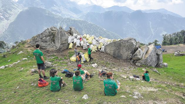 Members of Waste Warriors, a Dharamshala-based NGO, collect the litter left behind by trekkers along the Triund trail.(Burhaan Kinu/HT PHOTO)