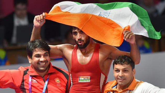 India's Bajrang Punia carries the tricolour after winning in the Finals of men's freestyle wrestling (65kg) against Japan's Daichi Takatani at the Asian Games 2018, in Jakarta on Sunday, August 19, 2018. (PTI)