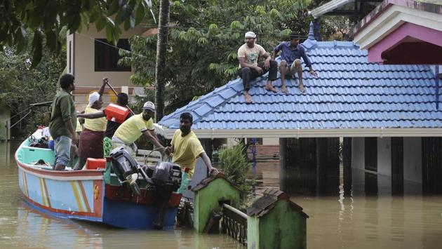 Volunteers reach in a boat to rescue stranded people from a flooded area in Chengannur in Kerala, Sunday, Aug.19, 2018.(AP)