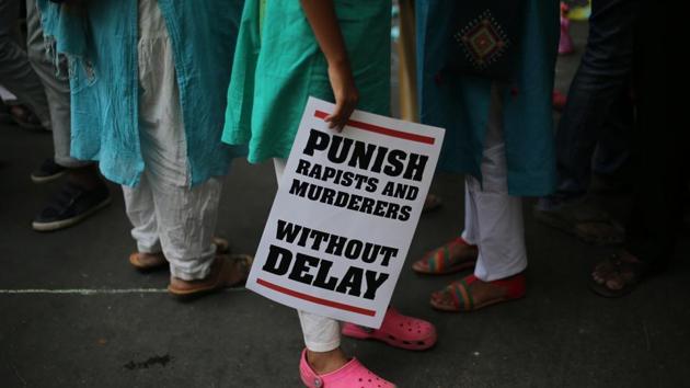 A protestor stands with a placard during a protest against rape cases in New Delhi.(AP Photo)