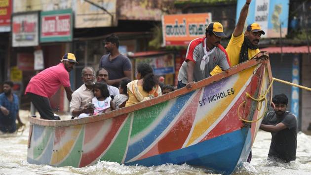 Local fishermen, volunteers and rescue personnel evacuate residents through a boat due to floods at Panadala, in district Pathanamthitta of Kerala on Saturday.(Raj K Raj/HT PHOTO)
