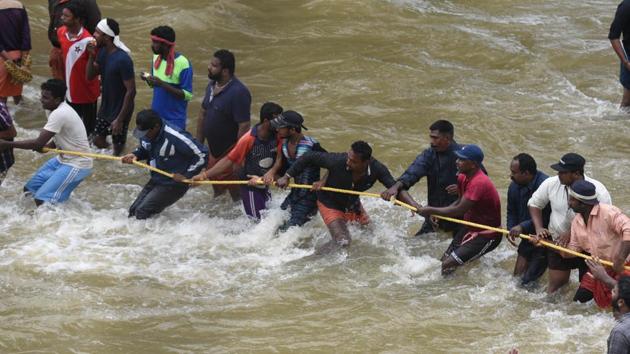 People wade through the flood waters to their marooned houses at Panadala, in district Pathanamthitta of Kerala, India, on Saturday, August 18, 2018. (HT Photo) People wade through the flood waters to their marooned houses at Panadala, in district Pathanamthitta of Kerala, India, on Saturday, August 18, 2018. (HT Photo)
