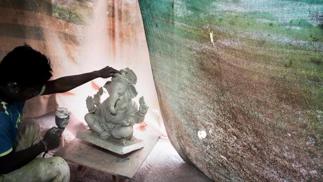 A worker begins spraying on the first coats of paint on to an idol. Apart from outside workers, this family run entity has Hazare helped by his wife, son and daughter, son-in-law, daughter-in-law and their respective children. (Satish Bate / HT Photo) A worker begins spraying on the first coats of paint on to an idol. Apart from outside workers, this family run entity has Hazare helped by his wife, son and daughter, son-in-law, daughter-in-law and their respective children. (Satish Bate / HT Photo)