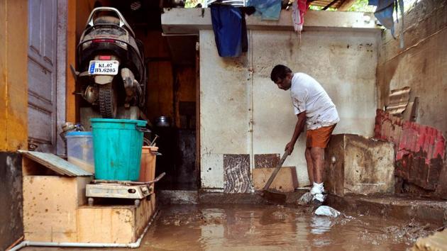 A man cleans the muddy floor of a building in Kochi, Kerala, on Monday.(AFP)