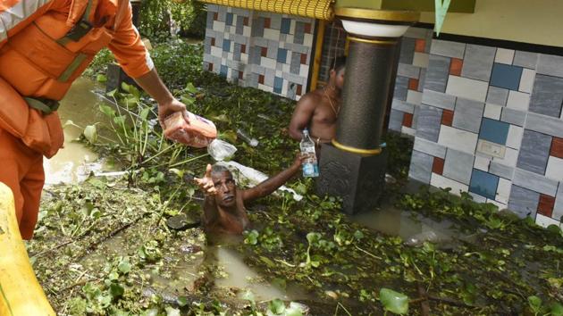 NDRF personnel hands over a packet of bread to a flood victim in Kerala’s Alappuzha district on August 20. (Raj K Raj/HT PHOTO) NDRF personnel hands over a packet of bread to a flood victim in Kerala’s Alappuzha district on August 20. (Raj K Raj/HT PHOTO)