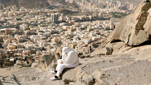 A muslim pilgrim prays while she climbs the Mount Al-Noor, where Muslims believe Prophet Mohammad received the first words of the Quran through Gabriel in the Hera cave. Thousands of buses and vehicles carrying the pilgrims lined the eight kilometre road from Mecca to Mina. (Zohra Bensemra / REUTERS)