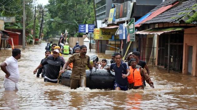 Rescuers evacuate people from a flooded area to a safer place in Aluva in Kerala.(Reuters Photo) Rescuers evacuate people from a flooded area to a safer place in Aluva in Kerala.(Reuters Photo)